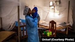 Moko na basali ya bokolongono azali kosali mwana na centre ya traitement ya Ebola, na Butembo, 13 août 2019. (Unicef)