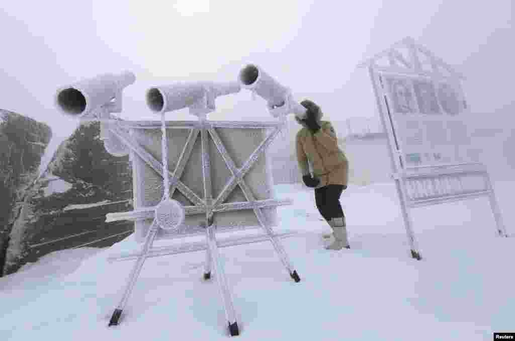 A woman looks through a telescope, covered with hoarfrost, with the air temperature at about minus 38&deg; C (- 36.4&deg; F) on the bank of the Yenisei River in the Siberian village of Ovsyanka near Krasnoyarsk, Russia, Jan. 20, 2018.