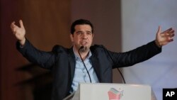 Alexis Tsipras, pemimpin partai sayap kiri Syriza di Yunani, berpidato pada para pendukungnya di luar Athens University, Minggu (25/1). (AP/Lefteris Pitarakis)