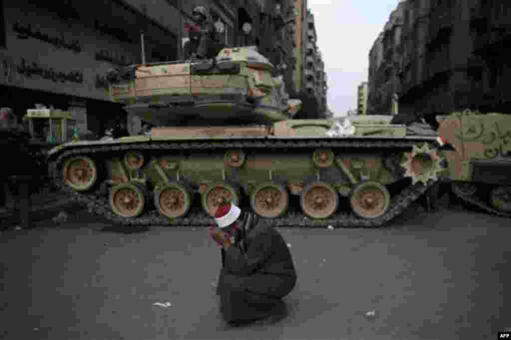 An Egyptian Muslim cleric cries in front of on army tank in Tahrir, or Liberation square, in Cairo, Egypt, Wednesday, Feb. 2, 2011. Several thousand supporters of President Hosni Mubarak, including some riding horses and camels and wielding whips, clashed