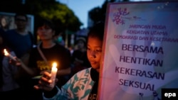 Warga menyalakan lilin dalam unjuk rasa menuntut perlindungan negara terhadap perempuan di depan Istana Negara, Jakarta (4/5). (EPA/Mast Irham)