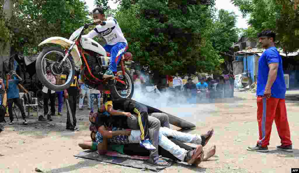 A man performs stunts with his motorcycle during the rehearsal for the forthcoming Lord Jagannath Rath Yatra, an annual Hindi festival, in Ahmedabad, India.