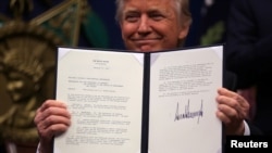 Le président Donald Trump montre un décret qu’il a signé dans le but d’empêcher les terroristes étrangers d'entrer aux États-Unis au Pentagone à Washington, le 27 janvier 2017.