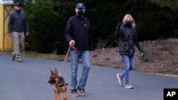 Presiden AS Joe Biden dan ibu negara Jill Biden berjalan kaki bersama anjing peliharaan mereka di Pantai Rehoboth, Delaware, 28 Desember 2021. (Foto: Patrick Semansky/AP)