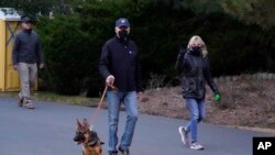 Presiden AS Joe Biden dan Ibu Negara Jill Biden mengajak anjingnya yang bernama Commander untuk berjalan-jalan di Pantai Rehoboth, Delaware, AS, Selasa, 28 Desember 2021. (Foto: AP/Patrick Semansky)