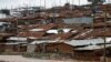 FILE - A man watches a stream from his home in Nairobi's Kibera slum, Kenya, Dec. 3, 2019. 