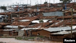 FILE - A man watches a stream from his home in Nairobi's Kibera slum, Kenya, Dec. 3, 2019. 