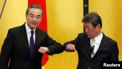 Ngoại trưởng Trung quốc Vương Nghị (trái) chào hỏi vị tương nhiệm Nhật Bản, Ngoại trưởng Toshimitsu Motegi trước cuộc hội đàm ngày 24/11/2020 tại Tokyo. REUTERS/Issei Kato/Pool 