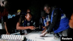 Electoral officials count votes during the presidential and parliamentary election at a polling station in Bole, Ghana, Dec. 7, 2024.