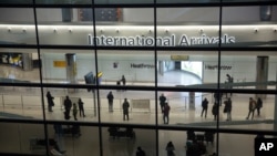 Personas en el área de llegadas del aeropuerto de Heathrow en Londres, el martes, 26 de enero de 2021.