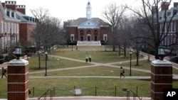 In this Feb. 26, 2019 photo, people walk across a quad at Johns Hopkins University in Baltimore. (AP Photo/Patrick Semansky)