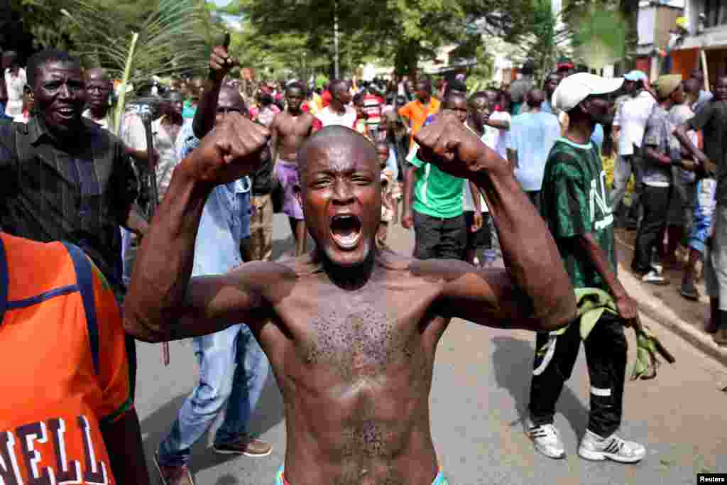 A man gestures as he celebrates in Bujumbura, Burundi May 13, 2015. Crowds poured onto the streets of Burundi's capital on Wednesday to celebrate after a general said he was dismissing President Pierre Nkurunziza for violating the constitution by seeking