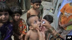 Petugas Kesehatan Pakistan memberikan vaksinasi polio untuk anak-anak di Lahore, Pakistan (foto: dok). Kawanan bersenjata membunuh seorang polisi yang mengawal tim kesehatan. 