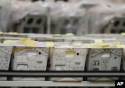 Boxes with ballots sit on tables at the Palm Beach County Supervisor of Elections office during a recount, Nov. 14, 2018, in West Palm Beach, Florida.