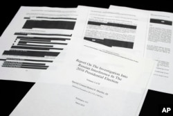 LFour pages of the Mueller Report lay on a witness table in the House Intelligence Committee hearing room on Capitol Hill, in Washington, Thursday, April 18, 2019. (AP Photo/Cliff Owen)