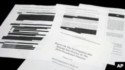 Four pages of the Mueller Report lay on a witness table in the House Intelligence Committee hearing room on Capitol Hill, in Washington, Thursday, April 18, 2019. (AP Photo/Cliff Owen)