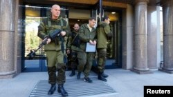 Prime minister of the self-proclaimed "Donetsk People's Republic" (DNR) Alexander Zakharchenko (C) walks out of a building housing the DNR's Central Election Commission in Donetsk, eastern Ukraine, Oct. 11, 2014.