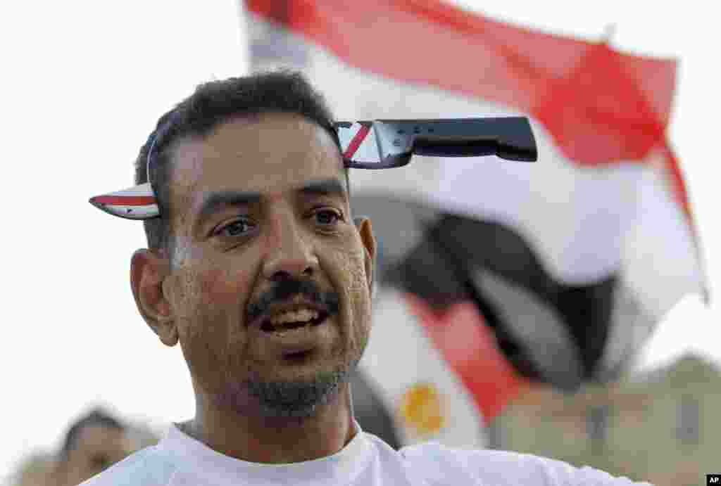 An opponent of Egypt&#39;s ousted President Mohamed Morsi wears a toy knife on his head in Cairo&#39;s Tahrir Square following dawn prayers marking the Eid al-Fitr feast at the end of the Muslim month of Ramadan.