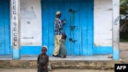 A shop owner closes down his shop on March 7, 2018 in Mocimboa da Praia, Mozambique. Security is increased in the area following attacks from suspected islamists in October.