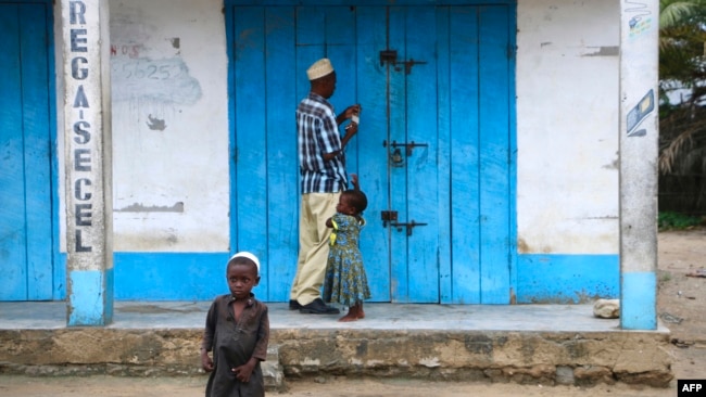 A shop owner closes down his shop on March 7, 2018 in Mocimboa da Praia, Mozambique. Security is increased in the area following attacks from suspected islamists in October.