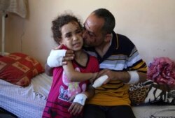 Suzy Ishkontana, 7 tahun, dicium ayahnya, Riad Ishkontana, 42, di Rumah Sakit Shifa di Kota Gaza, Selasa, 18 Mei 2021. (Foto: AP/Abdel Kareem Hana)