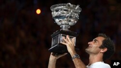 Roger Federer mengangkat Piala Australia Terbuka setelah menjuarai laga tunggal putra, di Melbourne, Australia, 28 Januari 2018.