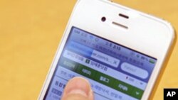 韩国首尔的一位消费者使用iPhone 4流览网页