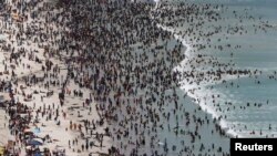 Des milliers de personnes affluent pour célébrer le Jour de l'An sur la plage de Muizenberg au Cap, 1 janvier 2015.