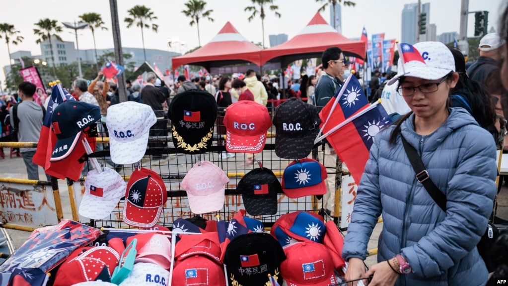 2024年1月7日，在总统大选前一周，一名街头小贩在高雄主要反对党国民党的竞选集会上出售台湾旗帜和帽子。（法新社照片）