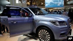 FILE - A man steps out from a Lincoln Navigator SUV on display at the China Auto Show in Beijing, April 25, 2018. Used, once-leased Lincoln vehicles are among the cars available as subscriptions in San Francisco.