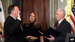 Vice President Mike Pence, right, swears in CIA Director Mike Pompeo, left, as Pompeo's wife Susan, center, holds the Bible in the Vice President's Ceremonial Office in the Eisenhower Executive Office Building in the White House complex in Washington, Jan. 23, 2017.
