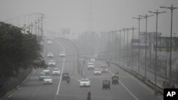 Vehicles move through morning smog on the last day of a two-week experiment to reduce the number of cars to fight pollution in New Delhi, India, Jan. 15, 2016. 