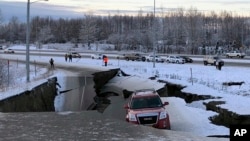 A car is trapped on a collapsed section of the offramp of Minnesota Drive in Anchorage, Nov. 30, 2018. 
