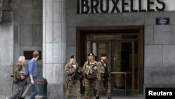 Tiga anggota pasukan keamanan Belgia melakukan patroli di luar stasiun kereta di Brussels, di mana ditemukan paket mencurigakan, Minggu (19/6). 