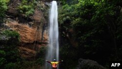 Un turista aparece frente a una cascada durante la reapertura gradual del turismo en El Salvador, luego de la cuarentena obligatoria para prevenir nuevas infecciones de COVID-19, en San Julián, Sonsonate, el 30 de septiembre de 2020.