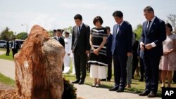 PM Jepang Shinzo Abe (nomer dua dari kanan) didampingi istrinya, Akie (nomor dua dari kiri) mengheningkan cipta di Darwin, Australia, Sabtu , 17 November 2018, untuk menghormati 80 awak kapal selam Jepang I-124, yang tenggelam di Darwin pada Januari 1942. 