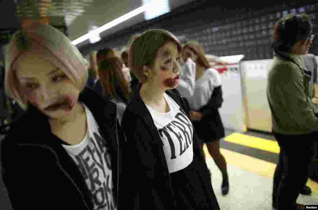 Participants wearing costumes and make-up as zombies wait for a train at a subway station after a Halloween event to promote the U.S. TV series "The Walking Dead" in Tokyo, Oct. 31, 2013.