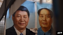 现任中共总书记习近平和前中共领导人毛泽东的画像并排挂在北京的一个市场上(2017年9月19日)