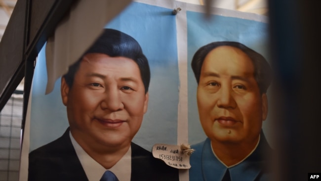 中国主席习近平与毛泽东画像并排挂在北京的一家市场上，2017年9月19日。