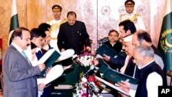 In this photo released by Pakistan's Press Information Department, Pakistan's President Mamnoon Hussain, front on left, administers oath to ministers in Islamabad, Pakistan, Aug. 4, 2017.
