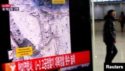 A passenger walks past a television report on North Korea's nuclear test at a railway station in Seoul February 12, 2013.