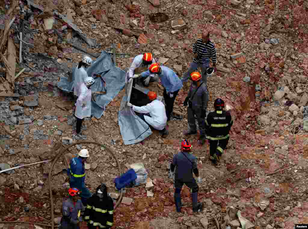 Forensic investigators examine the remains of a victim from a collapsed building in downtown Sao Paulo, Brazil, May 8, 2018.