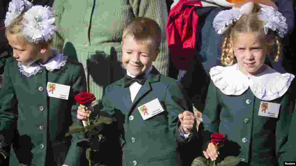 First-grade pupils attend a festive ceremony to mark the beginning of another academic year in Makiivka, eastern Ukraine, Oct. 1, 2014. 