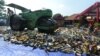 A steam roller machine destroys hundreds of alcohol drinks, pornographic and pirated video DVDs in a Jakarta police station, July 8, 2013.