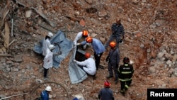 Tim investigasi forensik memeriksa kondisi jenazah korban reruntuhan gedung di Sao Paulo, Brazil, pada 8 Mei 2018. (Foto: Reuters/Leonardo Benassatto)