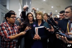 Sen. Lisa Murkowski, R-Alaska, walks with reporters as in the basement of the U.S. Capitol in Washington, Jan. 30, 2020.