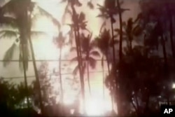 In an image from video, a flash from an explosion is seen from the ground during a fireworks show at a temple in Kollam, in the southern Indian state of Kerala, April 10, 2016.