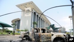 Burnt out cars are seen outside a government building, following an election protest in Libreville, Gabon, Sept. 1, 2016.