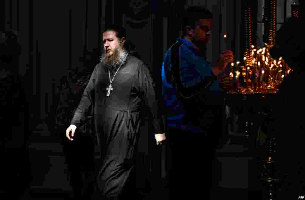 Rusya&#39;da bir Ortodoks rahip kilise önünde yürürken görüntülenmiş.