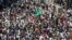 A national flag is seen amidst the supporters of Muhammad Tahirul Qadri, Sufi cleric and leader of political party Pakistan Awami Tehreek (PAT), as they gather to listen to his speech during the Revolution March in Islamabad, Aug. 16, 2014.